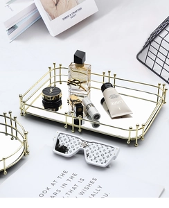 Détail d'un plateau miroir rectangulaire en métal doré avec bordure décorative perlée chic