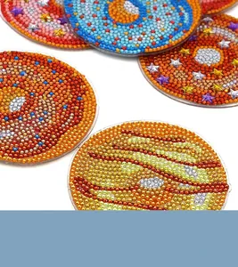 Makroaufnahme von DIY-Diamantmalerei-Untersetzern mit funkelnden Planeten- und Weltraum-Motiven