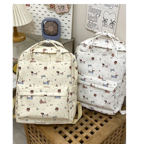 Close-up of cute sausage dog cartoon print and polka dot pattern on canvas backpack