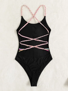 One-piece black swimsuit with colorful braided straps on a soft white plush backdrop