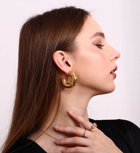 Close-up of 18K gold plated asymmetric star and drop zircon earrings and ring on model