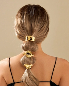 Close-up of three gold geometric metal hair ties styled on a ponytail for a modern look