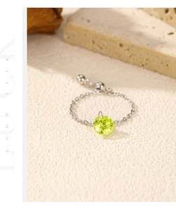 Adjustable silver chain ring with a sparkling olive green gemstone and 'GOOD LUCK' text