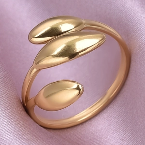 Makroaufnahme des goldenen 304 Edelstahl-Wickelrings mit drei Blättern auf rosa Seide