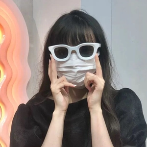 Detail shot of white chunky frame sunglasses with dark lenses on a female model
