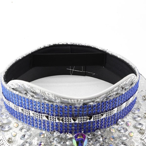 Macro detail of silver sequins and blue rhinestones on a stylish captain hat with elastic strap