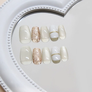 Short square handmade press-on nails featuring white cat eye effect and gold glitter accents