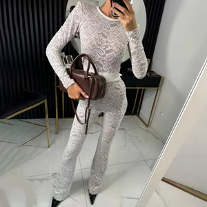 Detail shot of white lace long sleeve jumpsuit with elegant mesh stitching and slim fit design