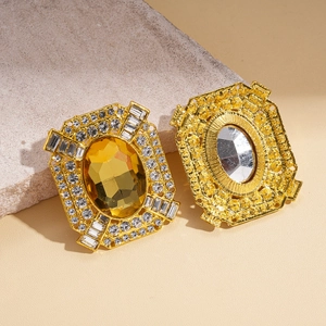Détails de boucles d'oreilles dorées avec pierres ovales jaunes et cristaux