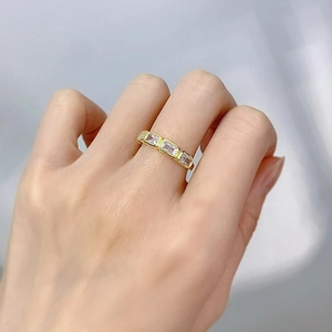 Close-up of gold plated ring with four rectangular cut cubic zirconia on a model's finger