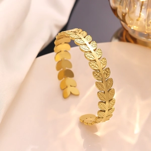 Detailed macro view of golden olive leaf cuff bracelet with textured vein patterns