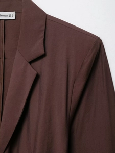 Macro view of dark coffee blazer neckline showing MWOMAN label and fabric texture