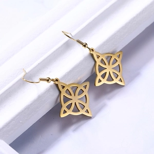 Detailed view of golden Celtic Witch Knot drop earrings on a white display stand
