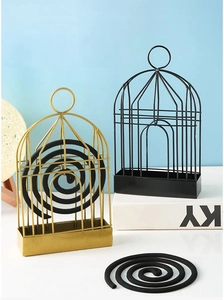 Detail of birdcage iron mosquito coil holder with hanging hook and ash tray in black and gold