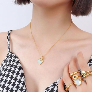 Collier avec pendentif étoile en acier titane plaqué or 18k et nacre porté par mannequin