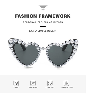 Detailed close-up of heart-shaped sunglasses with pearl-studded frames and UV protection