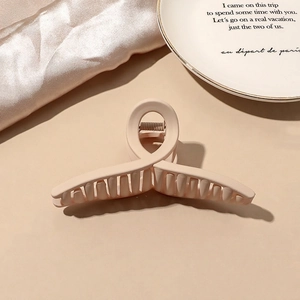 Close-up of matte beige claw clip showing its smooth texture and spring mechanism