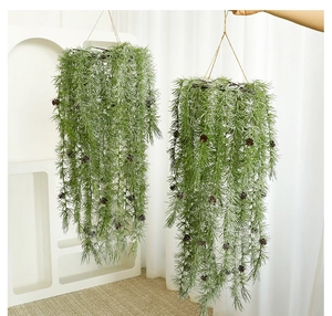Detail of hanging artificial pine needles with white frost and natural pine cones decor