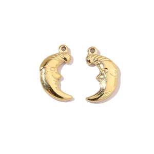 Macro shot of mirror-polished gold stainless steel moon face jewelry pendants on white
