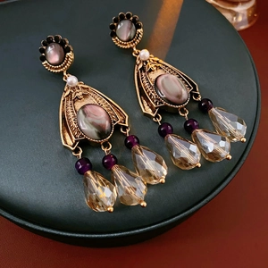 Close-up of vintage flower earrings with grey stones, purple beads and amber crystal tassels