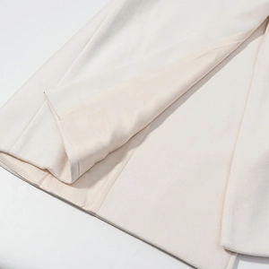 Close-up of cream wool coat detailing smooth satin lining and premium fabric texture