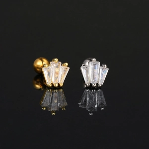 Macro shot of gold and silver screw-back earrings with fan-shaped cubic zirconia stones