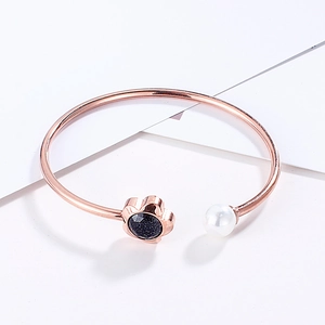 Detail of rose gold flower bangle with white pearl and blue sparkling sandstone gem