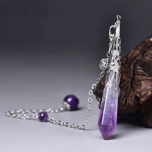 Macro detail of natural amethyst hexagonal pendant with ornate silver filigree cap