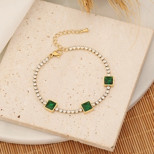 Détail du bracelet en or avec pierres précieuses vertes carrées et zircons blancs