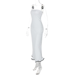 Dettaglio dell'abito lungo a fascia bianco con elegante bordo a balze nere sul fondo