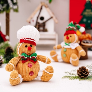 Detailed view of a knitted gingerbread man plush toy with a chef hat and bow tie