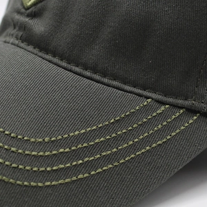 Macro shot of cotton baseball cap brim showing precise stitching and twill fabric texture