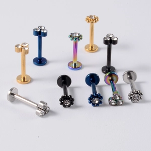 Vue macro de piercings labret en acier inoxydable avec zircons en diverses couleurs métal