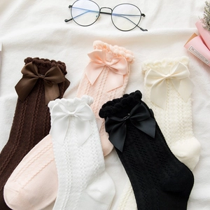 Detail of five pairs of cotton socks with cable knit textures and cute bow ties