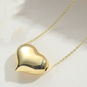 Vista macro di una collana con ciondolo a cuore placcata oro 14K con superficie lucida