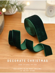 Detail of dark green velvet Christmas ribbon texture on a cozy festive wooden table