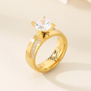 Detailed side view of golden four-prong ring with large center stone and pavé accents