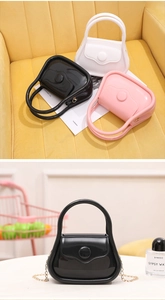 Detail of trendy PVC jelly bags in black, white and pink with golden chain straps