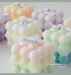Detailed close-up of colorful bubble cube scented candles in pastel pink and green