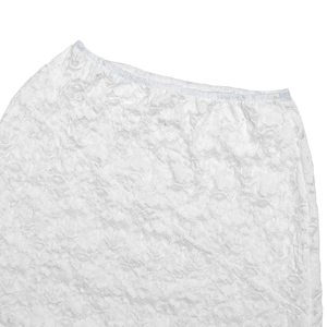 Close-up of intricate floral lace texture and stitching on a white high-waist skirt