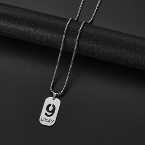 Detailed close-up of silver hollow number 9 pendant with LUCKY engraving on box chain