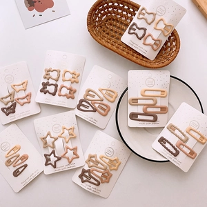 Detailed set of matte earth-tone hair clips in geometric and star shapes on a card