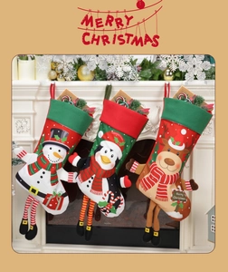 Three festive Christmas stockings with reindeer snowman and penguin hanging on fireplace