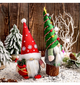Gros plan de gnomes de Noël faits main avec chapeaux en feutre et cadeaux dans la neige