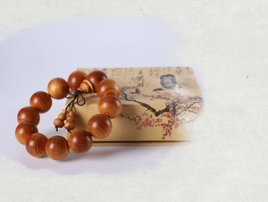 Macro shot of Thuja wood prayer beads with natural cloud patterns and gourd ornament