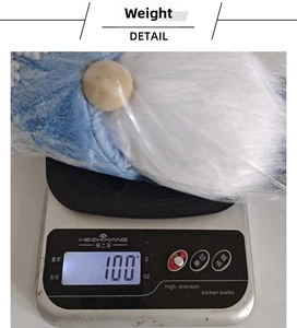 Detailed view of standing snowflake gnome plush toy weighing 100g on a digital scale