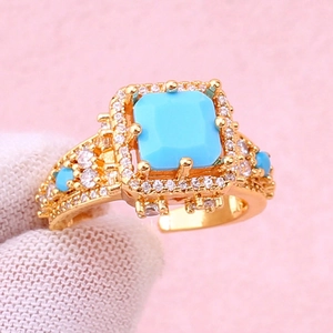 Adjustable gold plated ring featuring a square turquoise stone and zircon accents