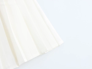 Détail de l'ourlet plissé soigné sur une élégante robe blanche sans manches raffinée