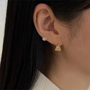 Macro view of 925 sterling silver twist earrings with shell texture on model