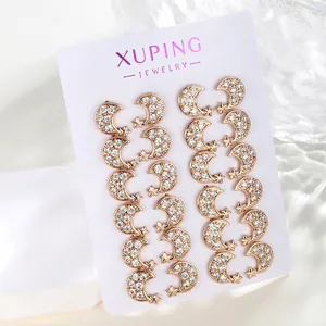 Detailed macro view of twelve pairs of gold moon and star stud earrings with white zircons